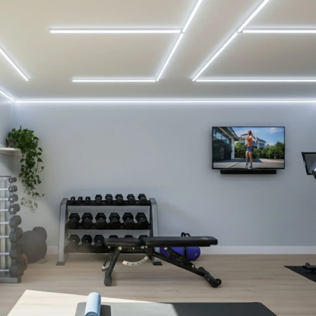 A sleek home gym featuring bright, linear LED ceiling lights and wall strips that illuminate the space. A large window shows a darker, less bright outdoor view, highlighting the inviting interior lighting. The gym is equipped with dumbbell racks, an exercise bench, a stationary bike, and a yoga mat on light wood flooring. A television on the wall displays a fitness instructor.