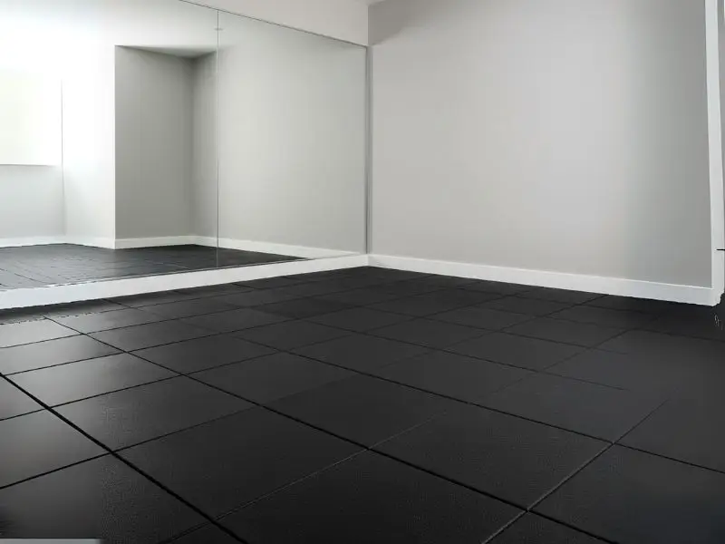 A view of a room with black interlocking rubber floor mats and a large wall mirror.